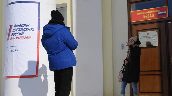 Молодые люди фотографируются после голосования на выборах президента России на избирательном участке №340 в Суздале