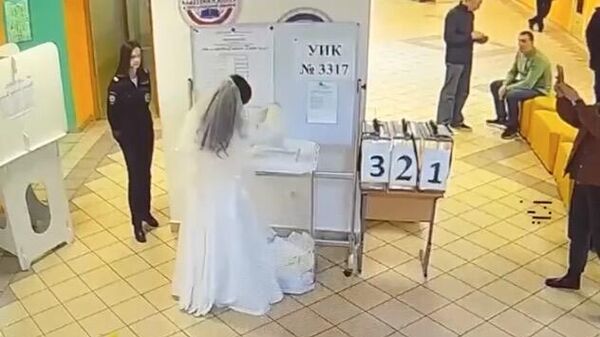 Невеста после свадьбы пришла проголосовать за президента РФ в Москве. Стоп-кадр видео 