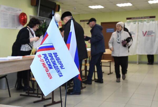 Люди регистрируются перед началом голосования на выборах президента России на избирательном участке №4126 во Владивостоке