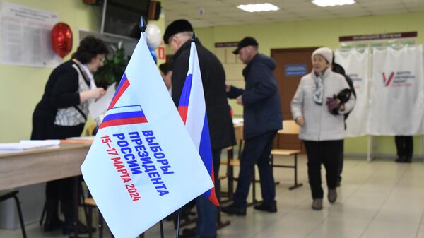 Люди регистрируются перед началом голосования на выборах президента России на избирательном участке №4126 во Владивостоке