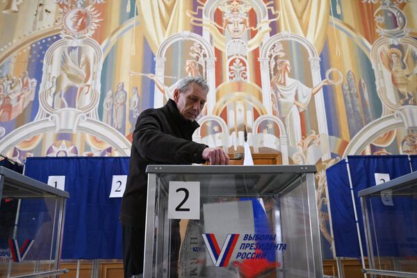 Мужчина голосует на выборах президента России на избирательном участке в Запорожской области