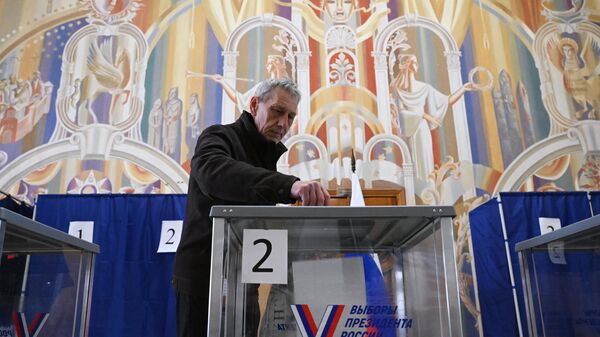 Мужчина голосует на выборах президента России на избирательном участке в Запорожской области