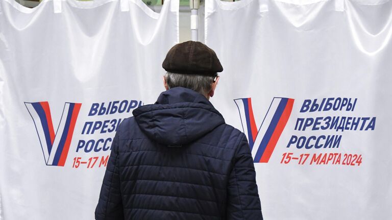 Мужчина голосует на выборах президента России на избирательном участке №4126 во Владивостоке