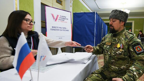 Мужчина голосует на выборах президента России на избирательном участке в Донецке