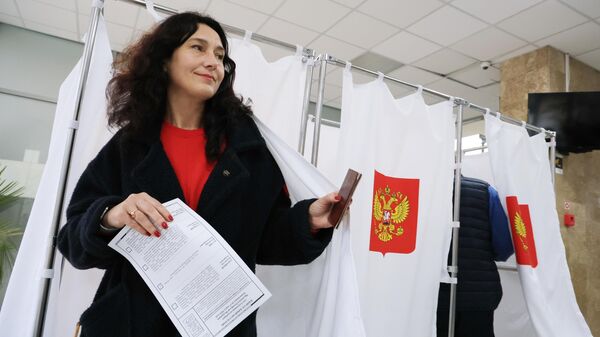 Девушка голосует на выборах президента России на одном из избирательных участков в Симферополе. 16 марта 2024