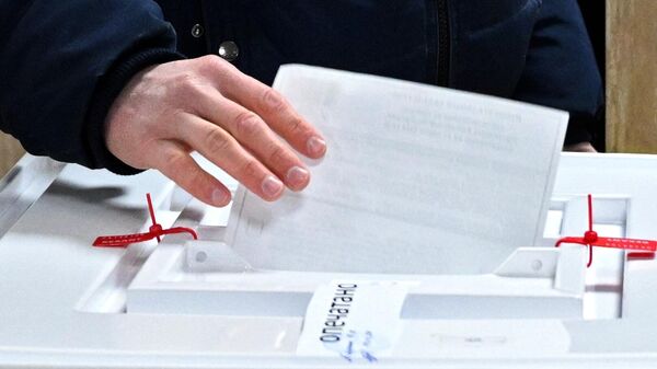 Мужчина голосует на президентских выборах на избирательном участке