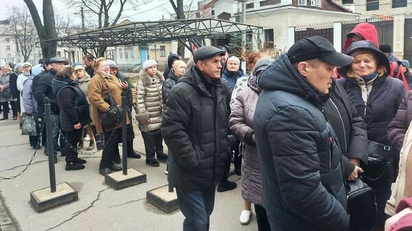 Люди стоят в очереди на избирательный участок для голосования на выборах президента России в Кишиневе
