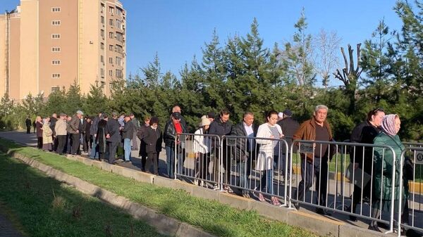 Люди стоят в очереди на избирательный участок для голосования на выборах президента России в Душанбе
