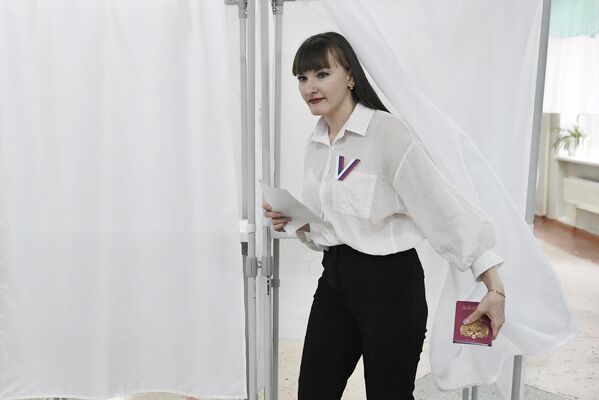 Женщина голосует на выборах президента России на избирательном участке в Константиновке