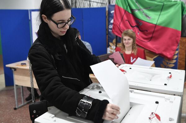 Девушка голосует на выборах президента России на избирательном участке в Константиновке