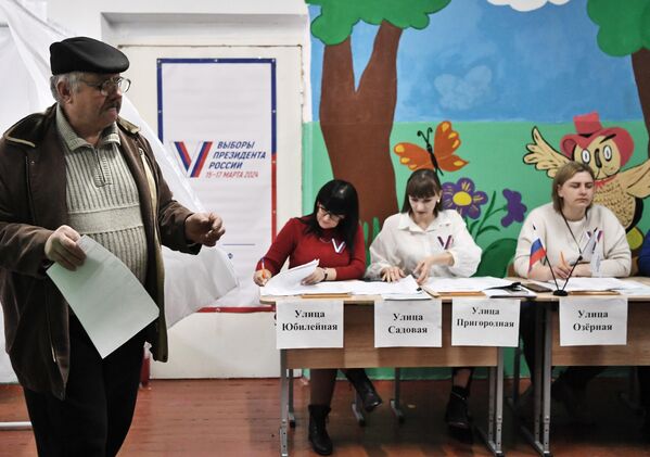 Мужчина голосует на выборах президента России на избирательном участке в Константиновке