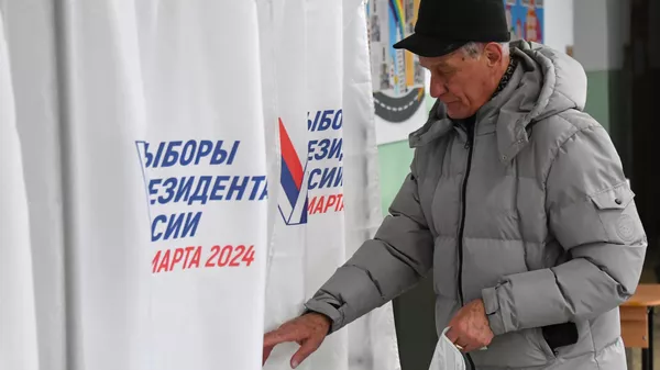 Мужчина голосует на выборах президента России на избирательном участке во Владивостоке Мужчина голосует на выборах президента России на избирательном участке во Владивостоке