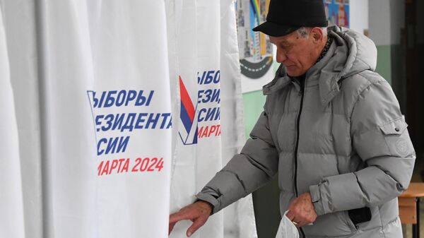Мужчина голосует на выборах президента России