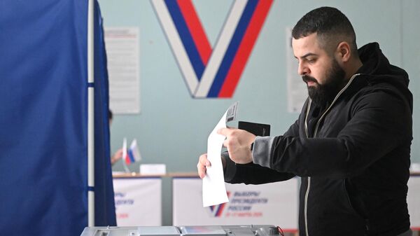Мужчина голосует на выборах президента России 