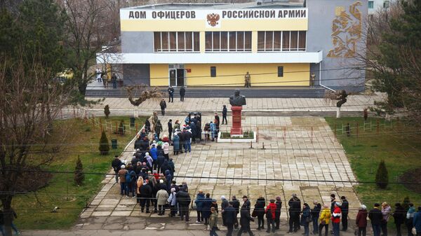Люди стоят в очереди на избирательный участок в Дом офицеров российской армии в Тирасполе для голосования на выборах президента России