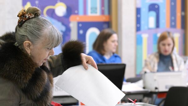 Женщина голосует на выборах президента России на избирательном участке  №2204 в здании Аничкова дворца в Санкт-Петербурге
