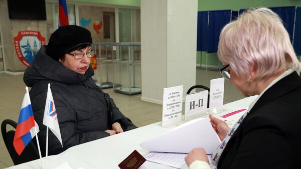 Женщина голосует на выборах президента России на избирательном участке в Макеевке. 15 марта 2024