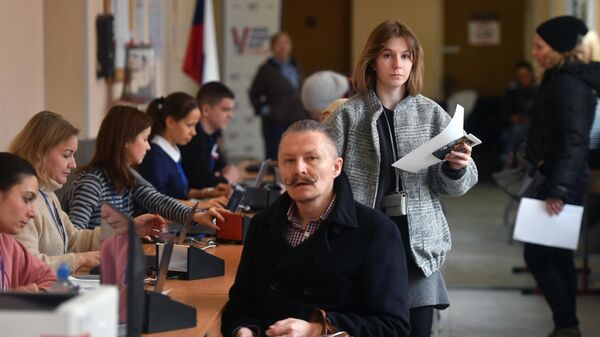 Люди голосуют на выборах президента России на избирательном участке школы №1282 Сокольники в Москве