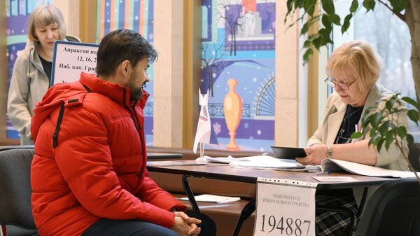 Мужчина регистрируется перед началом голосования на выборах президента России на избирательном участке  №2204 в здании Аничкова дворца в Санкт-Петербурге