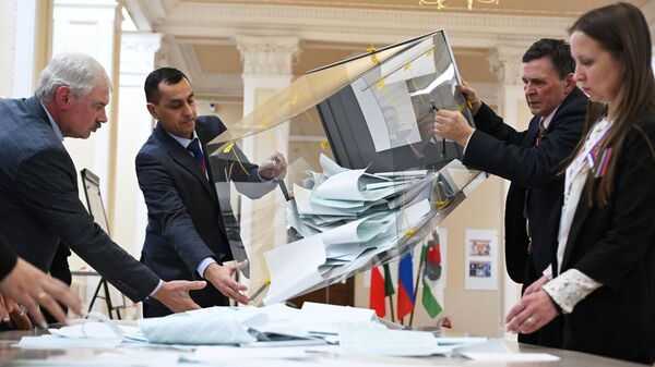 Члены участковой избирательной комиссии подсчитывают голоса после окончания процедуры голосования на выборах президента России на избирательном участке №42 в Казани