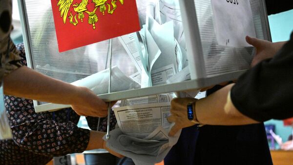 Члены участковой избирательной комиссии во время подсчета голосов после окончания процедуры голосования на выборах президента России