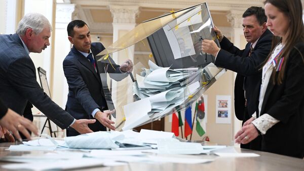 Члены участковой избирательной комиссии подсчитывают голоса после окончания процедуры голосования