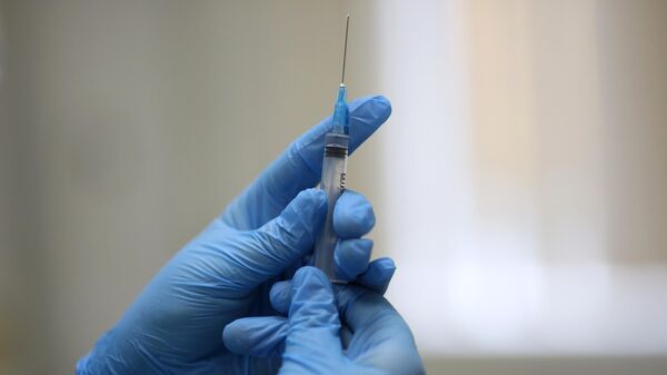Медсестра держит шприц перед прививкой