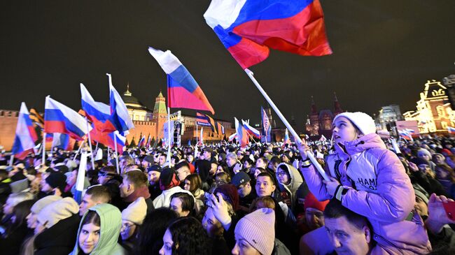 Зрители на митинг-концерте на Красной площади в Москве, посвященном десятилетию воссоединения Крыма с Россией