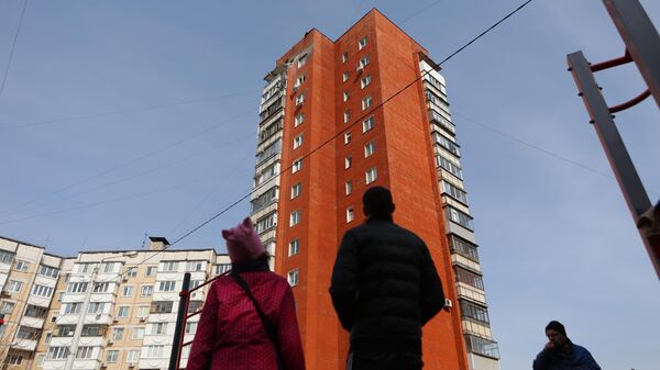 Люди у жилого дома, частично разрушенного в результате обстрела ВСУ в Белгороде
