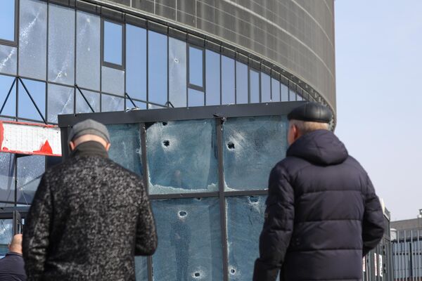 Жители Белгорода у здания многофункционального спортивно-развлекательного комплекса Белгород-Арена, частично разрушенного в результате обстрела ВСУ