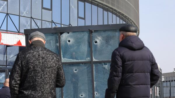 Жители Белгорода у здания многофункционального спортивно-развлекательного комплекса Белгород-Арена, частично разрушенного в результате обстрела ВСУ