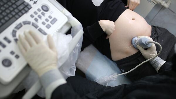 Медицинский работник делает УЗИ пациентке в роддоме