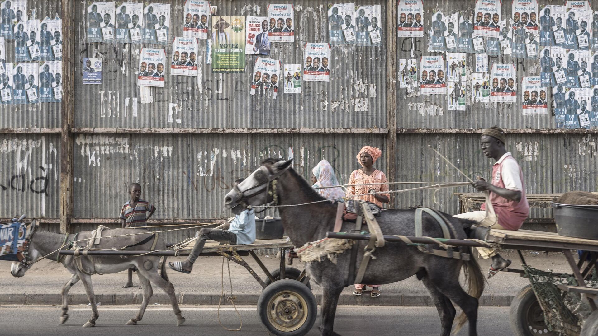 Местные жители проезжают мимо предвыборных плакатов в Даре, Сенегал  - РИА Новости, 1920, 24.03.2024