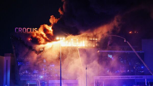 Пожарные тушат горящую крышу концертного зала Крокус Сити Холл, где произошла стрельба. Архивное фото