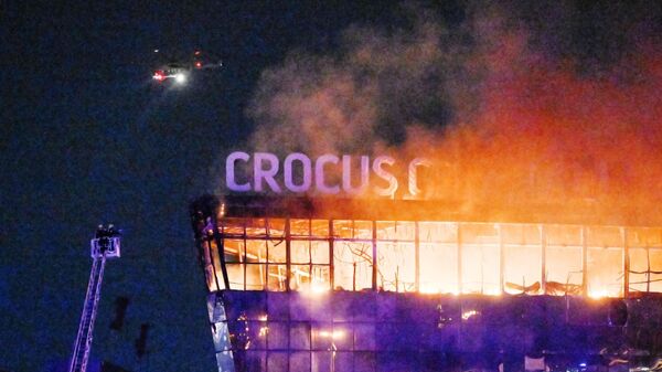 Вертолет надо горящим концертным залом Крокус Сити Холл, где произошла стрельба