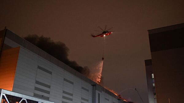 Пожарные тушат горящую крышу концертного зала Крокус Сити Холл, где произошла стрельба