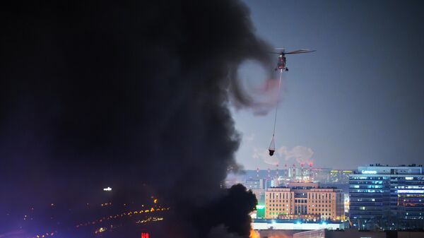 Пожарный вертолет во время тушения горящей крыши концертного зала Крокус Сити Холл