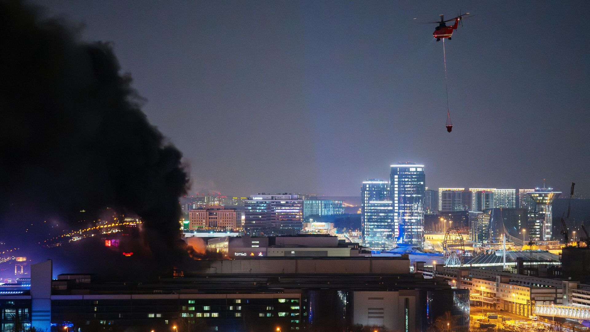Пожарный вертолет во время тушения горящей крыши концертного зала Крокус Сити Холл  - РИА Новости, 1920, 23.03.2024