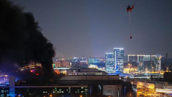 Пожарный вертолет во время тушения горящей крыши концертного зала Крокус Сити Холл 