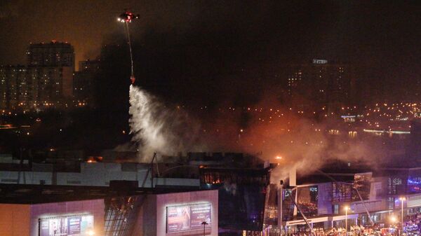Пожарный вертолет тушит горящий концертный зал Крокус Сити Холл, где произошла стрельба