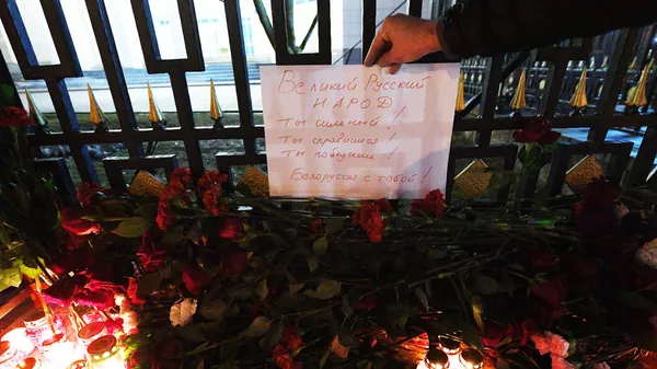 Цветы и свечи у Посольства России в Минске, где проходит акция в память о жертвах теракта в Крокус Сити Холле в Московской области
