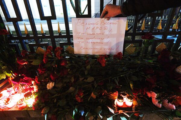 Цветы и свечи у Посольства России в Минске, где проходит акция в память о жертвах теракта в Крокус Сити Холле в Московской области