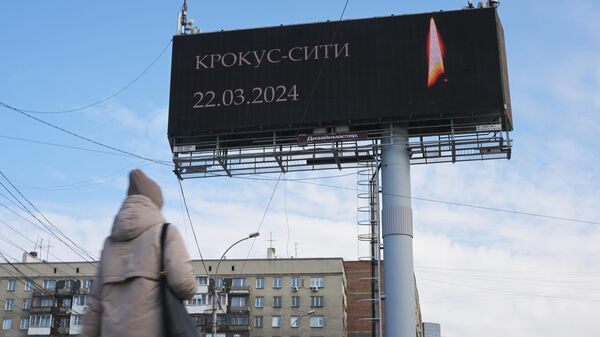 Медиаэкран с изображением свечи с траурной надписью на одной из улиц Новосибирска в память о жертвах теракта в подмосковном Крокус Сити Холле