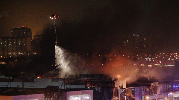 Пожарный вертолет тушит горящий концертный зал Крокус Сити Холл, где произошла стрельба3
