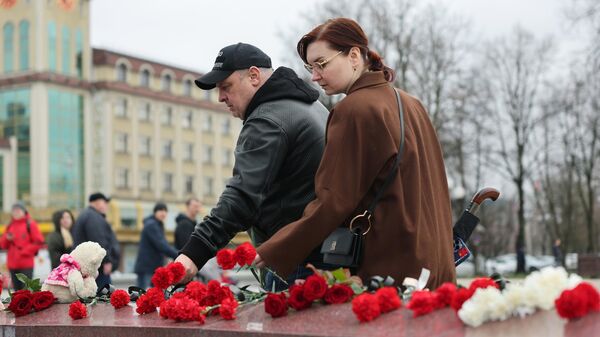 Люди возлагают цветы на площади Победы в Калининграде во время акции в память о жертвах теракта в подмосковном Крокус Сити Холле