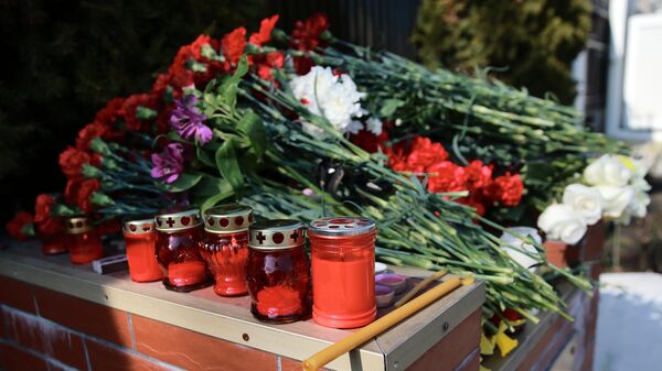 Цветы и свечи у стихийного мемориала