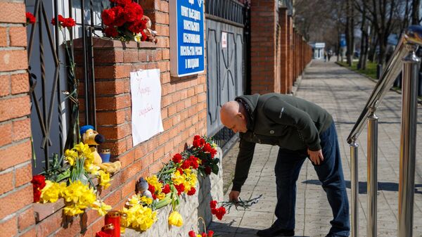 Мужчина возлагает цветы к стихийному мемориалу возле российского консульства в Тирасполе во время акции в память о жертвах теракта в подмосковном Крокус Сити Холле