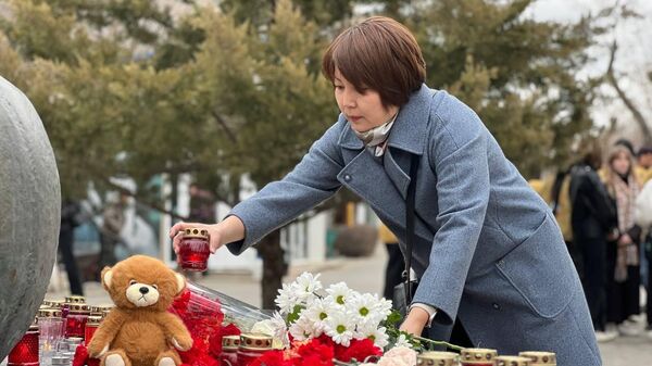 Жители Калмыкии возлагают цветы к стихийному мемориалу в центре Элисты в память о жертвах теракта в подмосковном Крокус сити холле