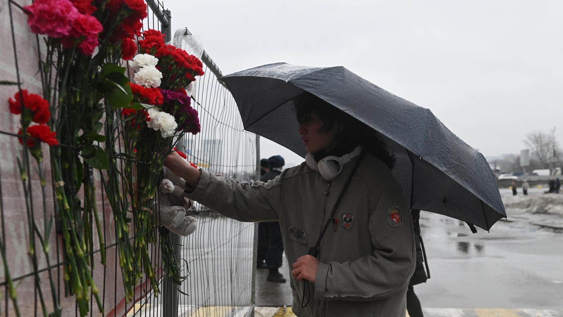 Люди несут цветы к зданию концертного зала Крокус Сити Холл. 23 марта 2024 - РИА Новости, 1920, 25.03.2024