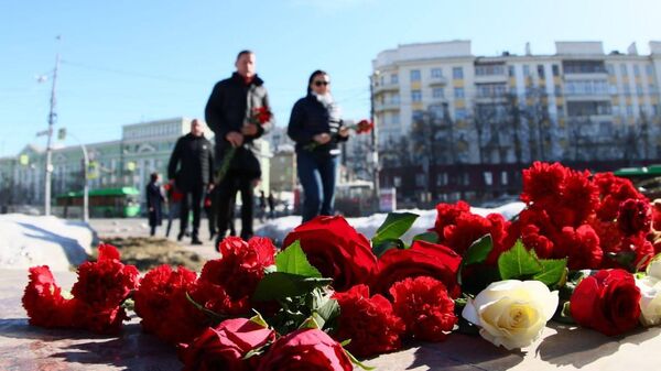 Жители Челябинска несут цветы к мемориалу в память о погибших в Крокусе